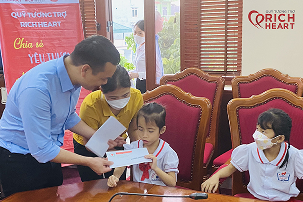 Ông Hà Anh Thái - Giám đốc Thương hiệu Công ty Cổ phần đầu tư Rich Invest trao quà cho các em học sinh có hoàn cảnh khó khăn tại Cô Tô